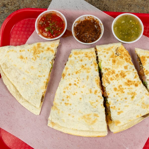 Burrito Bandito quesadillas cut into triangles, served with three small cups of salsa on a red tray.