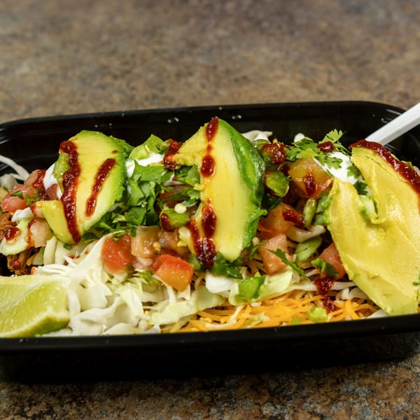Burrito Bandito's Mexican bowl with avocado, salsa, sour cream, and shredded lettuce in a black container.